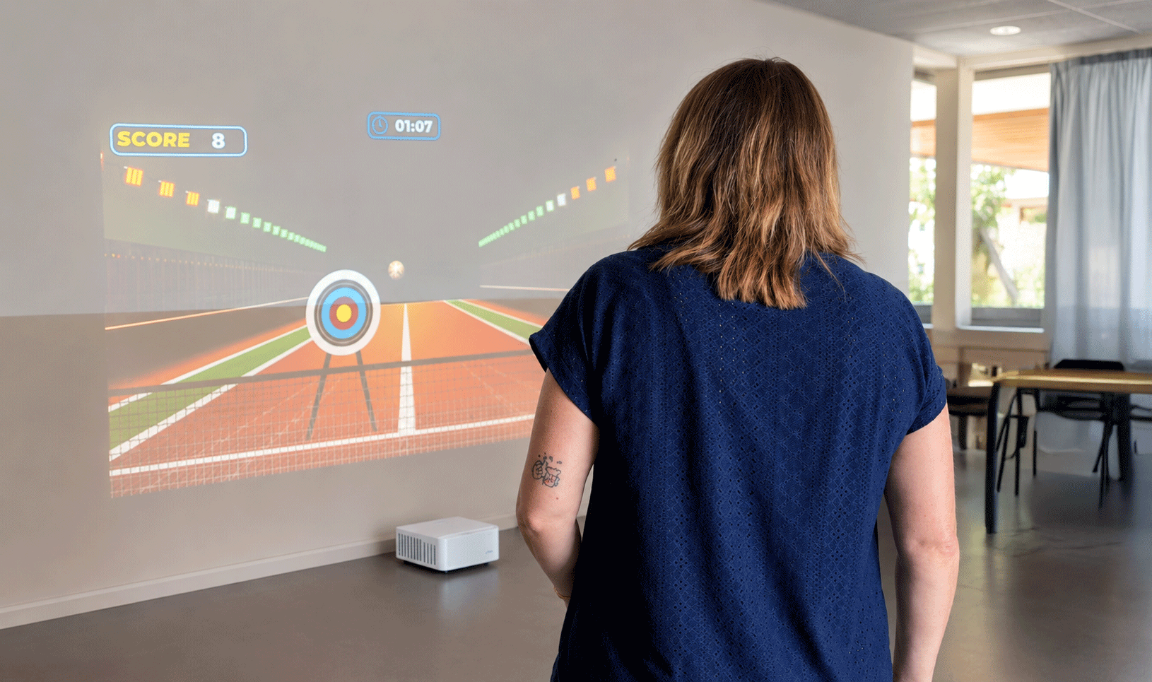 Animation Play'In Village au FJEP de Passy : une participante joue devant un mur interactif projeté