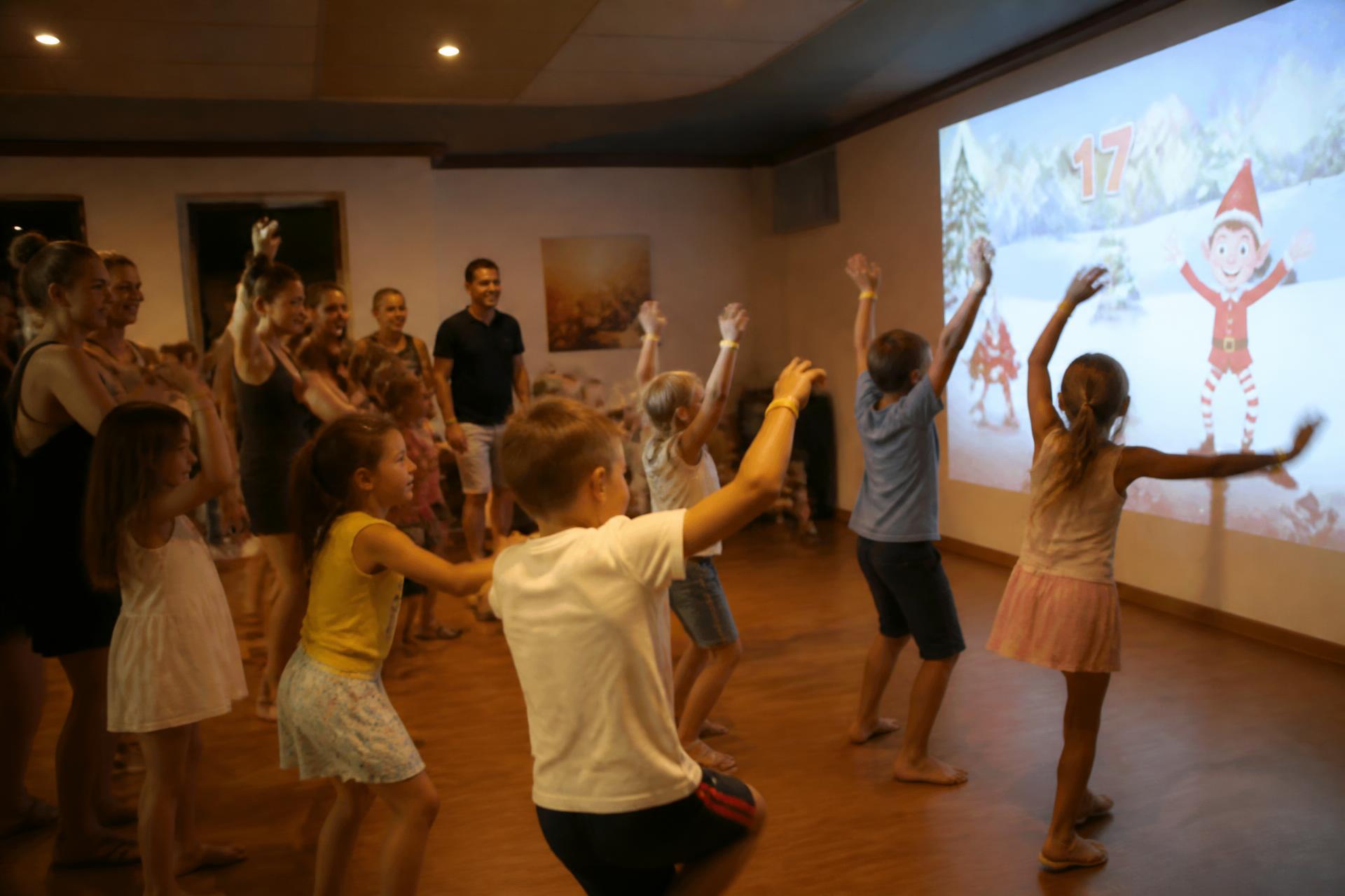 Animation Play'In Village en camping : parents et enfants jouent ensemble dans la salle d'animation du village vacances