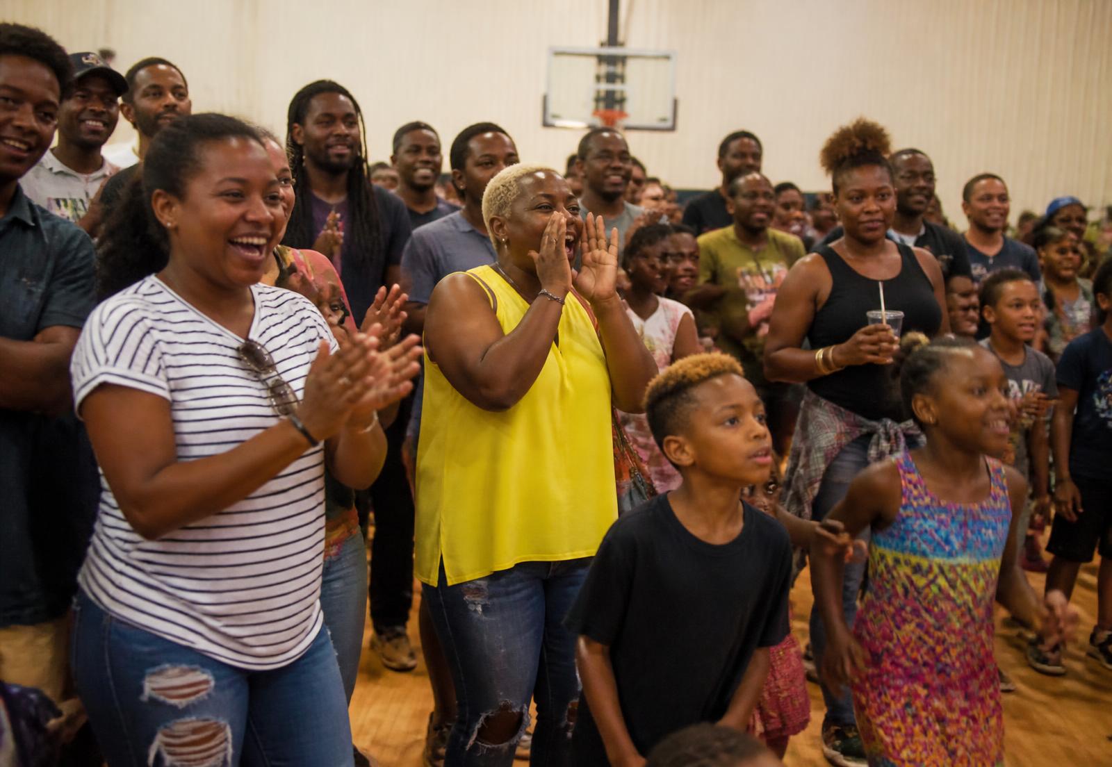 Familles et enfants qui participent et encouragent pendant une animation lors d'une fête locale